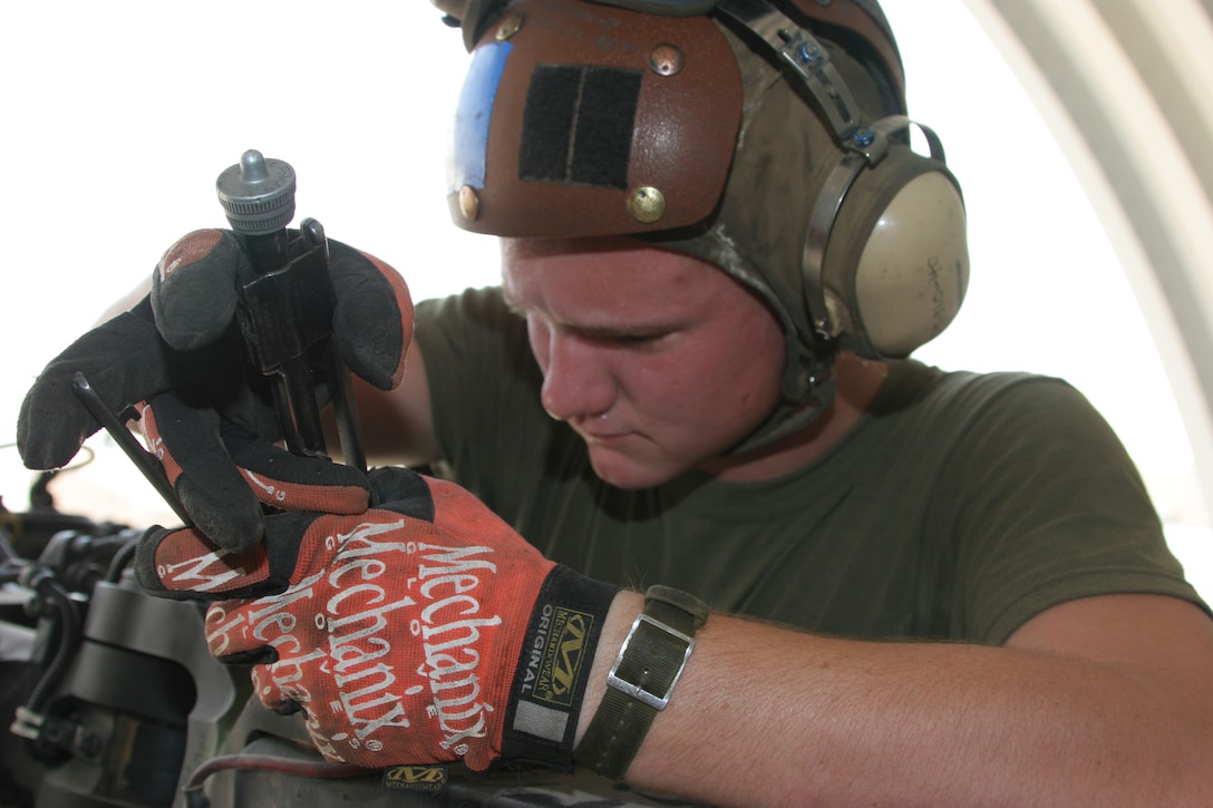AL TAQADDUM, Iraq ? Private first class Timothy Wade, a flightline mechanic with Marine Medium Helicopter Squadron 364 and Wortham, Texas, native, replaces a piece of safety wire on one of the blades of a Purple Fox CH-46E Sea Knight here. Cracks and blown seals have been the most common problem the phase crew has had to repair while deployed here.