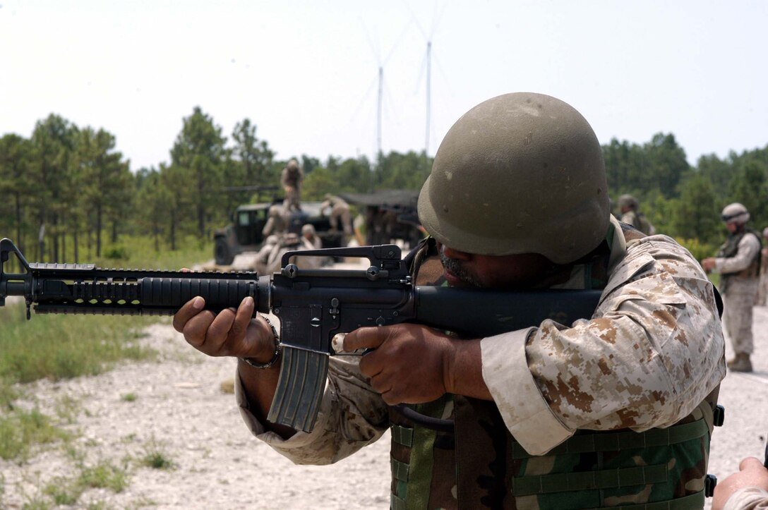 AL ASAD, Iraq - The Marines in the administrative section of Marine Aircraft Group 26 pose for a group photograph accompanied by the group headquarters squadron commanding officer and the group adjutant July 19.  Considered the backbone of the group, the administrators work 24 hours a day, seven days a week to make life easier for the more than 3,000 service members and Department of Defense civilians in the group.