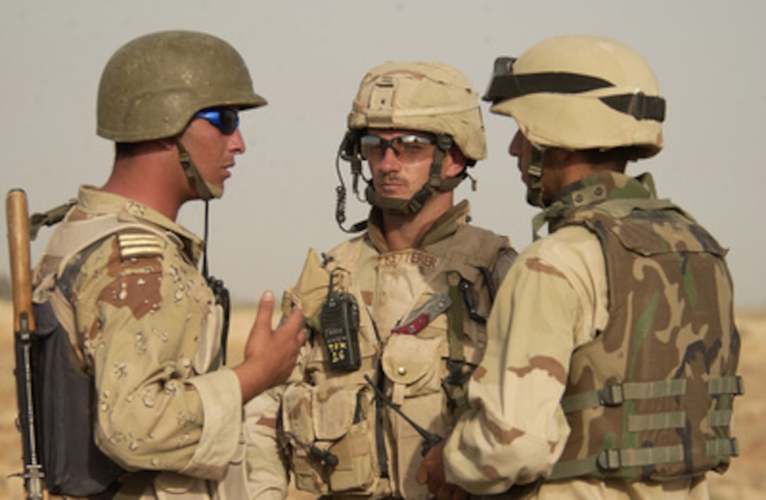 Iraqi Army soldiers from B Company, 3rd Platoon, 4th Battalion, work with U.S. Army 1st Lt. Todd Ketterer (center) as they prepare for a routine patrol in the town of Albu Suker, Iraq, on July 8, 2005. Ketterer is attached to Task Force Konohiki which is a U.S. Army team made up of soldiers from several units joined to train and evaluate Iraqi Forces. 