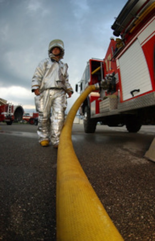 Air Force Senior Airman Jason McMillon stands by his fire truck as he waits for a signal to disconnect a hose during a an exercise at Aviano Air Base, Italy, on July 19, 2005. McMillon is a member of the 31st Civil Engineer Squadron Fire Department at Aviano. 