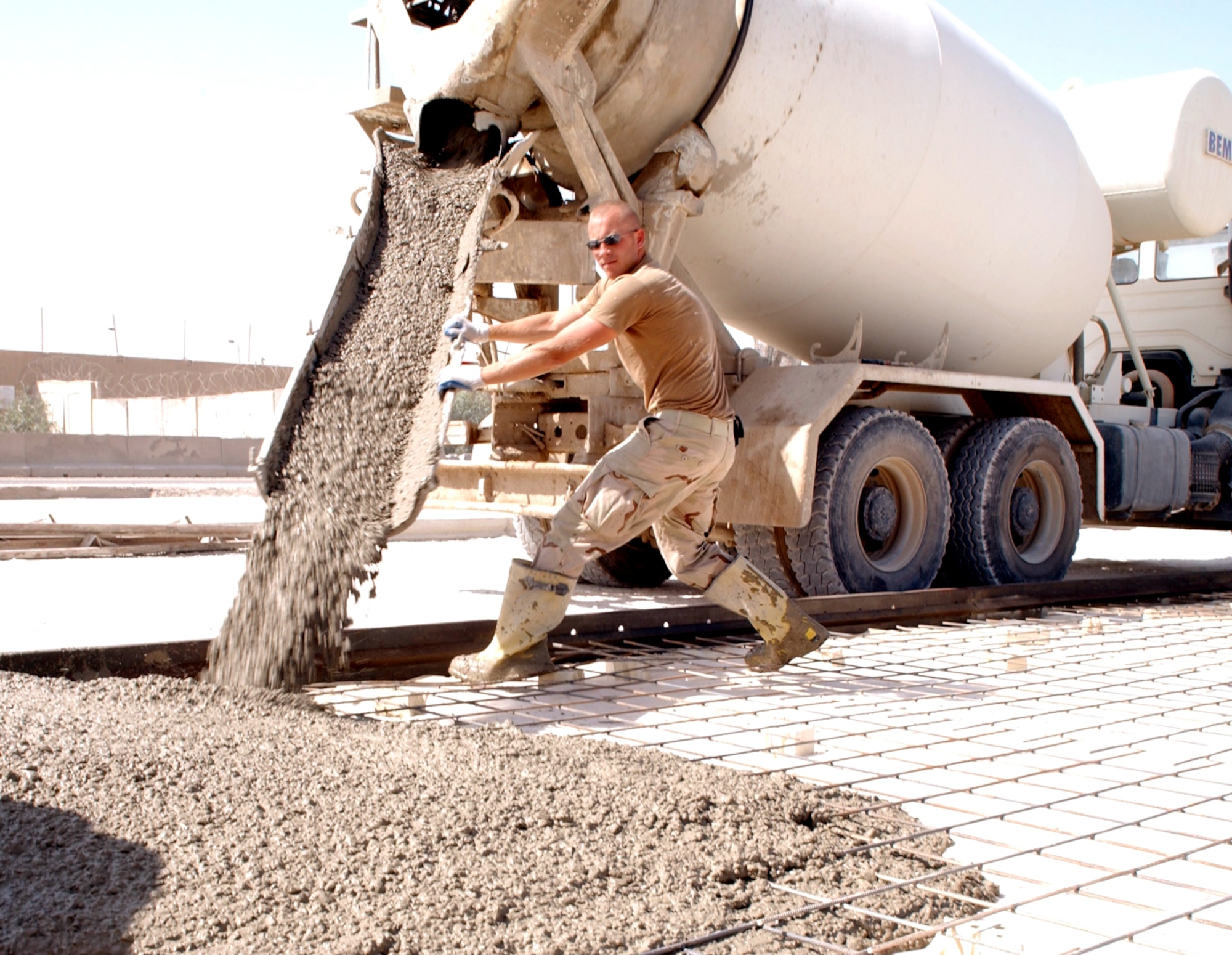 BAGHDAD, Iraq -- Staff Sgt. Brian Smetzer directs the concrete pouring at the main entry control point for the Baghdad International Airport complex.  The project will be used to improve security for civilians and coalition forces in the area.  He is deployed to the 557th Expeditionary Red Horse Squadron from the Pennsylvania Air National Guard.  (U.S. Air Force photo by Tech. Sgt. Brian Davidson)