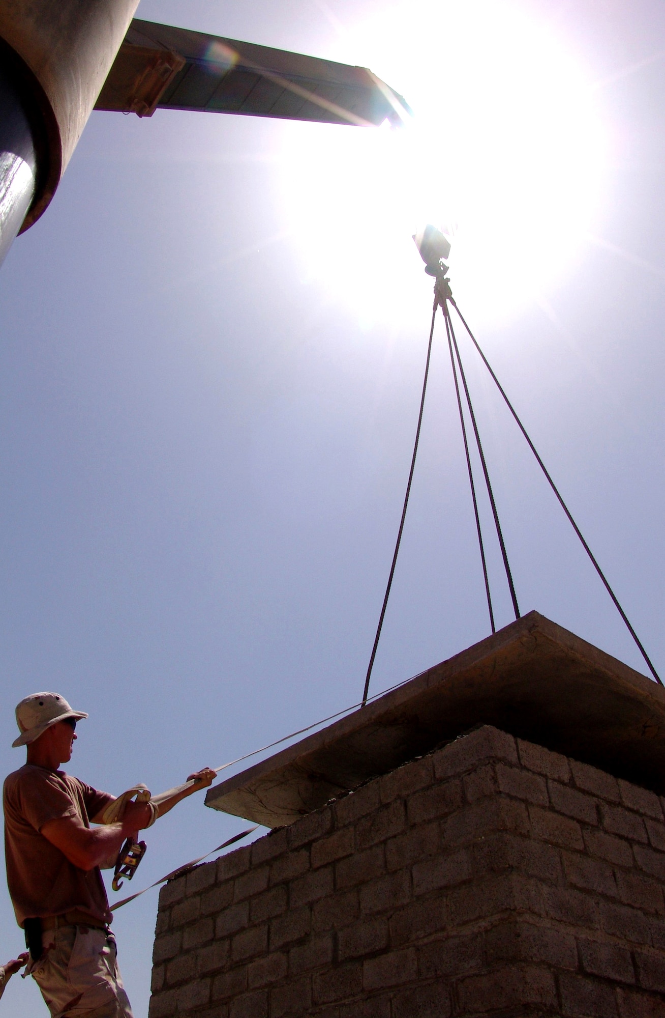 BAGHDAD, Iraq -- Senior Airman Chris Tobin guides a concrete roof onto a new network control center cable vault.  He is deployed to the 557th Expeditionary Red Horse Squadron from the Pennsylvania Air National Guard.  (U.S. Air Force photo by Tech. Sgt. Brian Davidson)                 