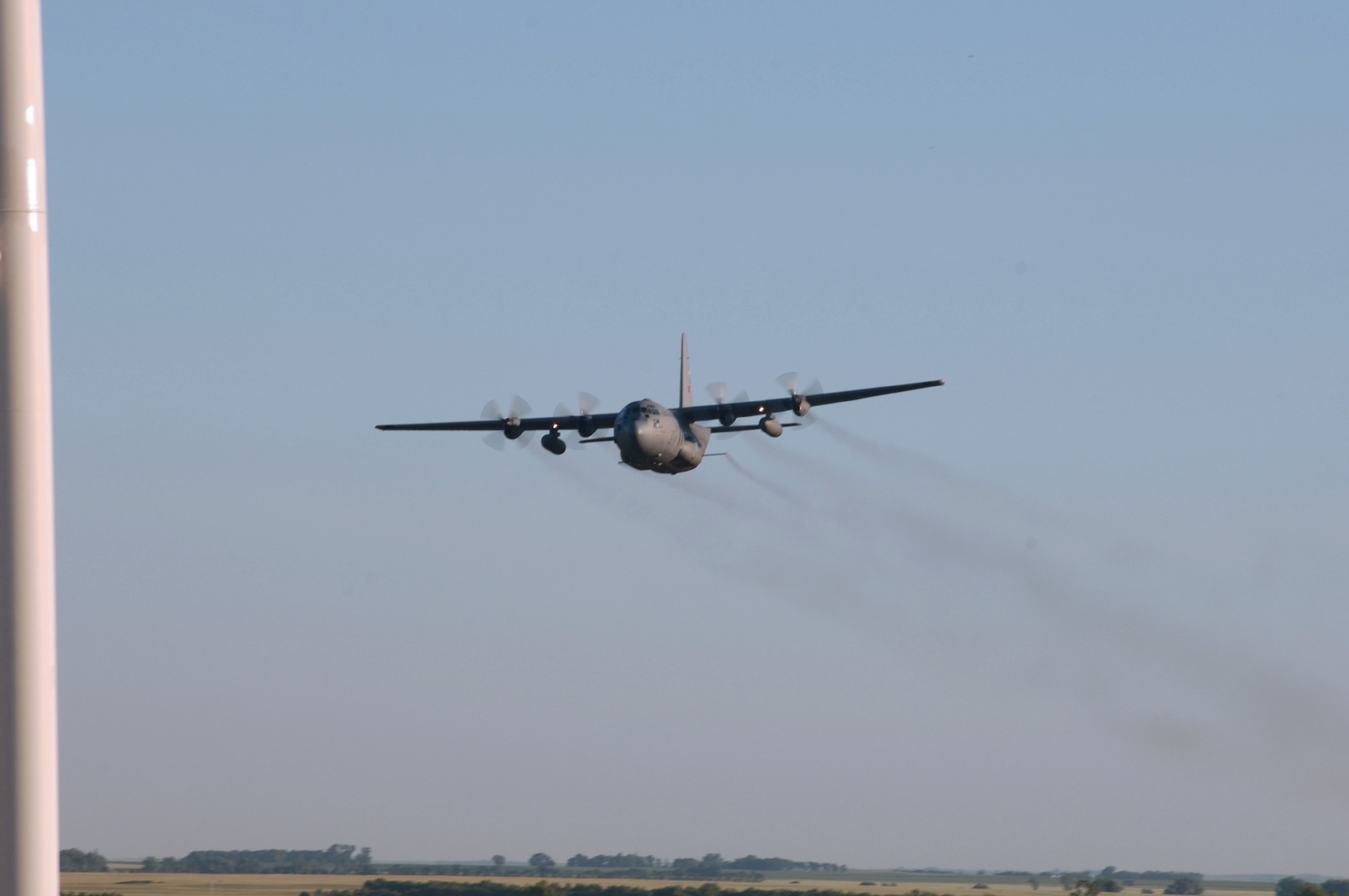 MINOT AIR FORCE BASE, N.D. -- A C-130 Hercules flies over the base July 19 while spraying for mosquitos. The aerial spraying helps control the mosquito population that has increased because of unseasonably wet weather.  The team is with the 757th Airlift Squadron from Youngstown Air Reserve Base, Ohio. (U.S. Air Force photo by Staff Sgt. Joe Laws)