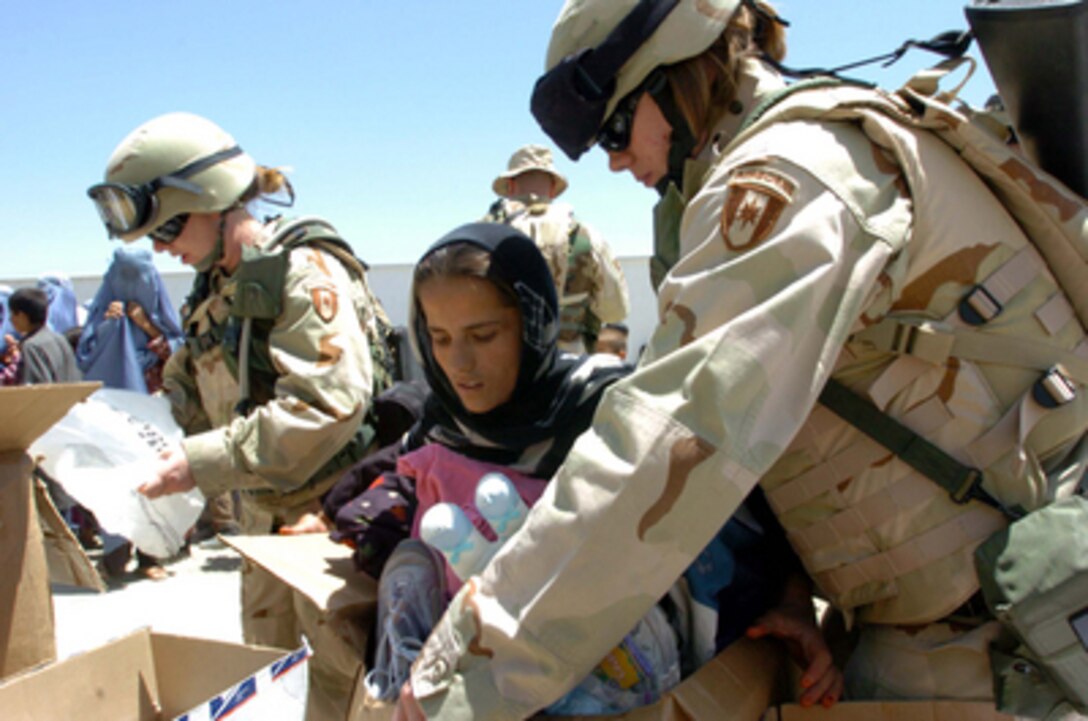 Soldiers from Task Force Strength hand out clothing, toys and personal hygiene items to Afghani women and children during a humanitarian assistance mission at a women's center outside Bagram, Afghanistan, on July 18, 2005. 