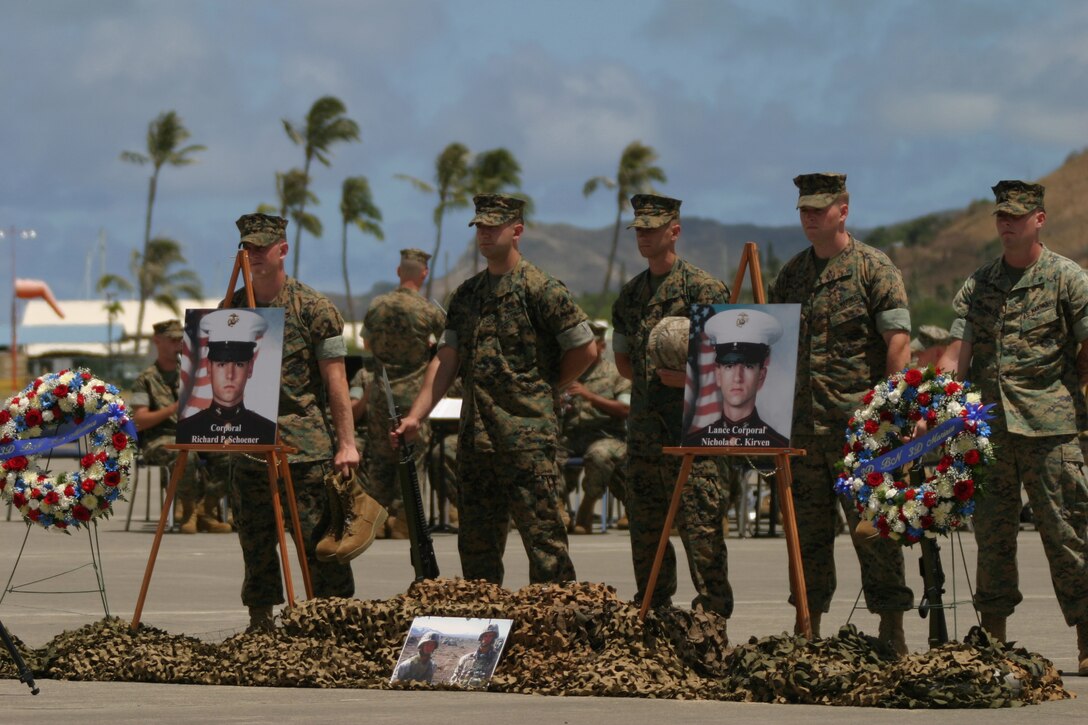 Marines stand tall behind pictures of Lance Cpl. Nicholas C. Kirven, and Cpl. Richard P. Schoener, were killed, May 8, during a firefight in Afghanistan. The Marines hold in thier hands boots, kevlars, rifles and dog tags that will be placed in a ceremonial way between the pictures in honor of them.