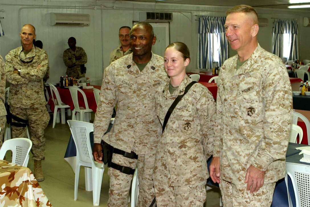 Cpl. Lisa M. Carey, an intelligence analyst assigned to Marine Wing Headquarters Squadron 2 and native of Homestead, Fla., poses for a photograph with the sergeant major of the Marine Corps, Sgt. Maj. John L. Estrada, and the Commandant of the Marine Corps, Gen. Michael W. Hagee on July 25.  Hagee and Estrada visited service members here to spend time with them and ensure they maintain operational situational awareness.