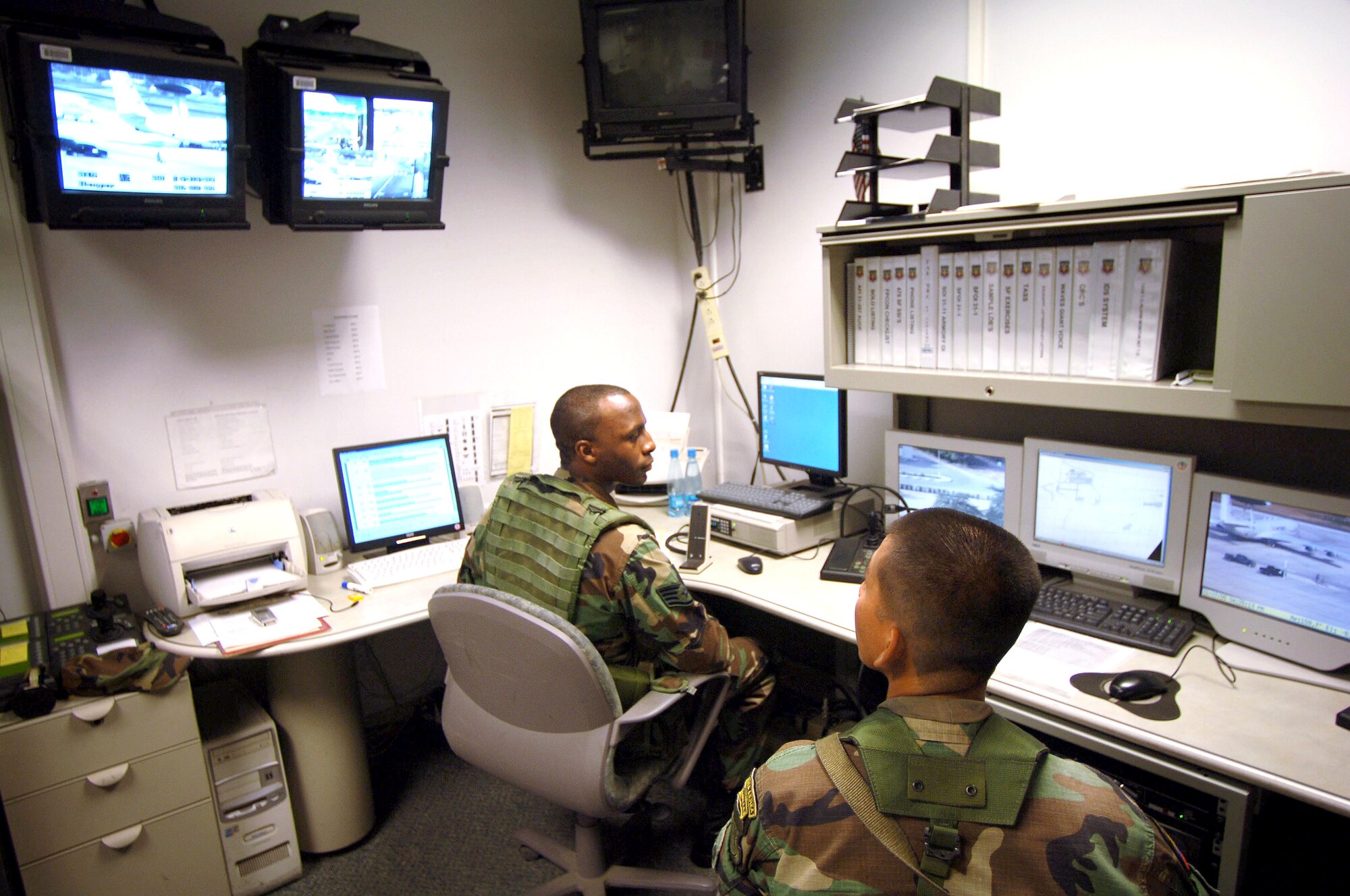 MANTA AIR BASE, Ecuador -- Staff Sgt. Eric Adams (left) works alongside his Ecuadorian counterpart, Geovanni Llongo, who is learning to use the equipment in a security forces control room.  Sergeant Adams is deployed here from Langley Air Force Base, Va.  (U.S. Air Force photo by Master Sgt. Efrain Gonzalez)