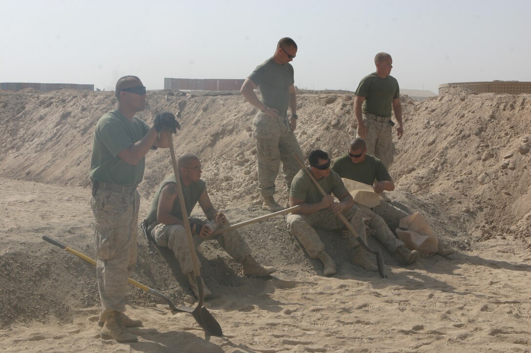 CAMP FALLUJAH, Iraq – Marines from Bulk Fuel, A Company, 6th Engineer Support Battalion, augmenting 8th ESB in direct support of Combat Logistics Bn. 8, 2nd Force Service Support Group (Forward), take a break from filling sandbags here July 26 during an expansion and renovation project Camp Fallujah’s fuel farm. (Photo by Cpl. John E. Lawson Jr.)