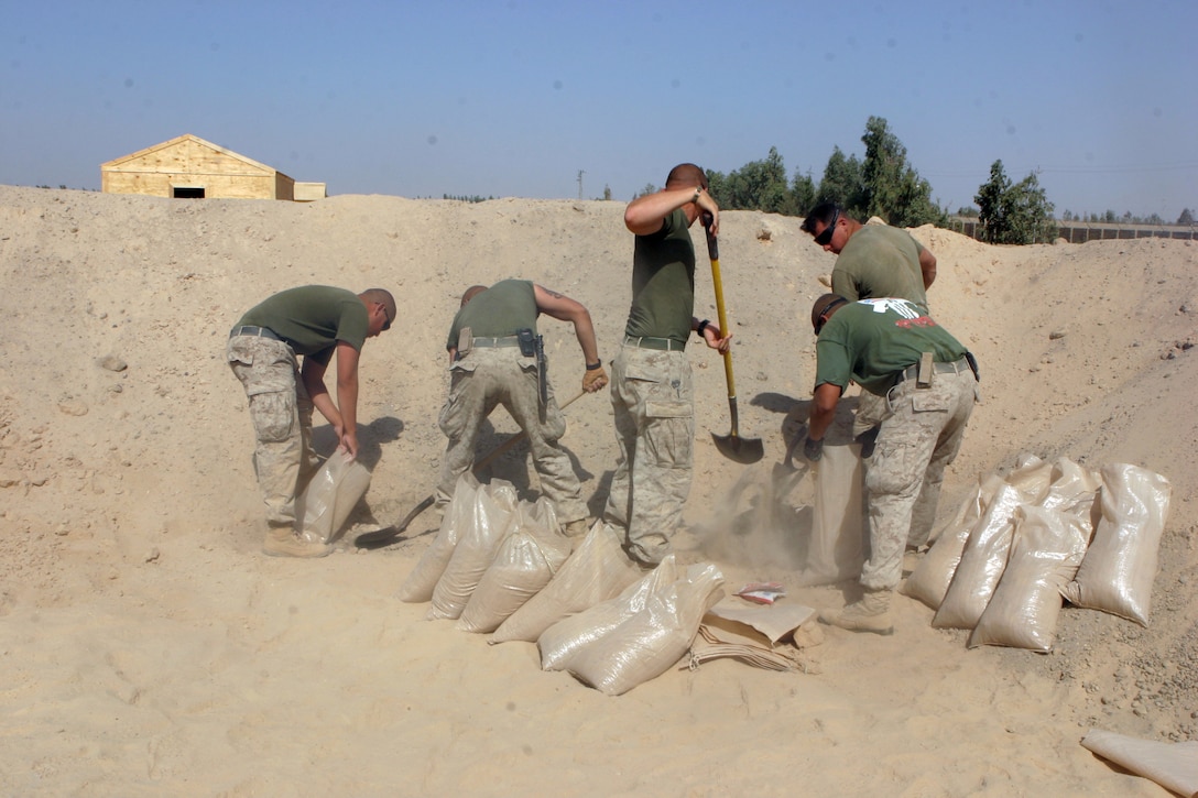 CAMP FALLUJAH, Iraq – Marines from Bulk Fuel, A Company, 6th Engineer Support Battalion, augmenting 8th ESB in direct support of Combat Logistics Bn. 8, 2nd Force Service Support Group (Forward), fill sandbags here July 26 during an expansion and renovation project Camp Fallujah’s fuel farm. (Photo by Cpl. John E. Lawson Jr.)