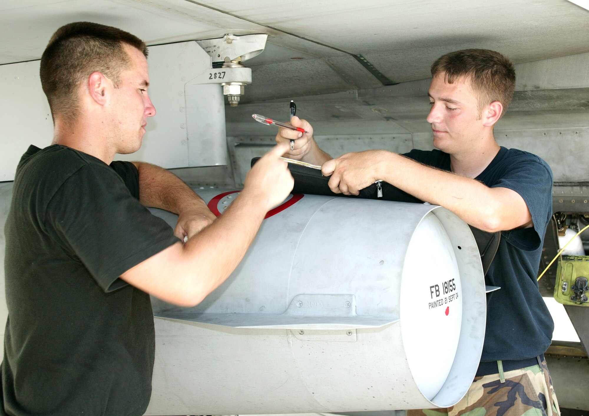 SHAW AIR FORCE BASE, S.C. -- Senior Airmen Stephen Yarbrough (left) and Mark Main sign in an F-16 Fighting Falcon after returning from Cape Canaveral, Fla., following the July 26 launch of the Space Shuttle Discovery.  The jet was one of six F-16s from here protecting the airspace around the launch site.  The Airmen are crew chiefs with the 55th Aircraft Maintenance Unit.  (U.S. Air Force photo by Senior Airman Susan Penning)