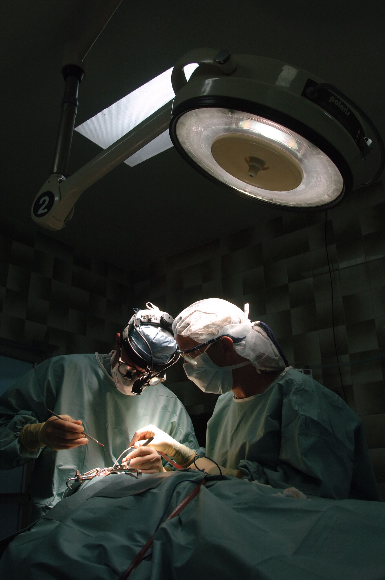 CUENCA, Ecuador -- Maj. (Dr.) Ted Ferguson (left) and Master Sgt. Kelly Mathis reconstruct a cleft lip at the military hospital here.  A seven-person plastic surgery team from Wilford Hall Medical Center at Lackland Air Force Base, Texas, is providing free corrective surgeries to Ecuadorian civilians as part of a 12-day medical readiness training exercise.  (U.S. Air Force photo by Master Sgt. Efrain Gonzalez)