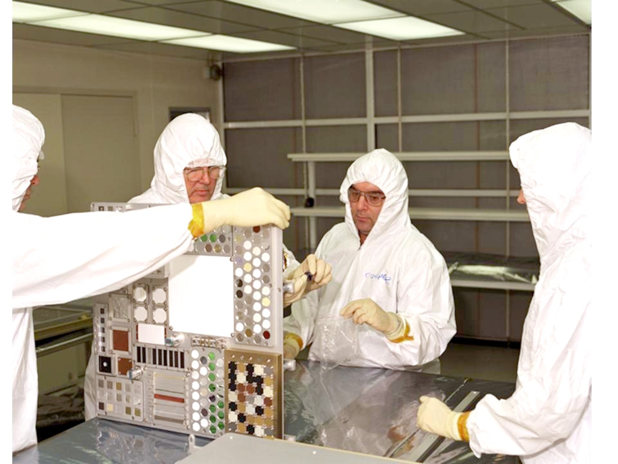 WRIGHT-PATTERSON AIR FORCE BASE, Ohio -- Air Force and NASA integrators attach experiment material samples to a passive experiment container that has been bolted to the International Space Station since 2001.  Air Force Research Laboratory scientists here are studying materials as part of the Materials on the International Space Station Experiment.  The Discovery shuttle crew will remove the carriers and return them to Earth as part of their return-to-flight mission which launched July 26. (U.S. Air Force photo)