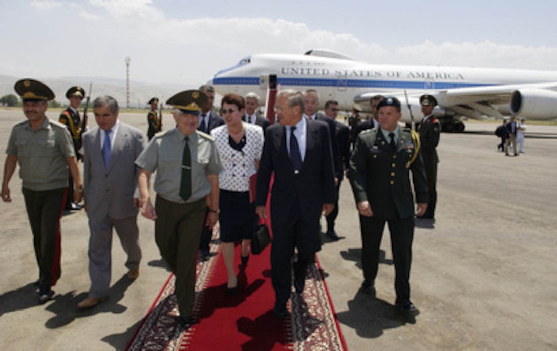 Secretary of Defense Donald H. Rumsfeld (2nd from right) talks with Tajikistan Minister of Defense Col. Gen. Sherali Khayrulloyev (4th from right) after arriving in Dushanbe, Tajikistan, on July 26, 2005. Rumsfeld is in Tajikistan to meet with Khayrulloyev and President Emomali Rahmonov to discuss bilateral military cooperation. 
