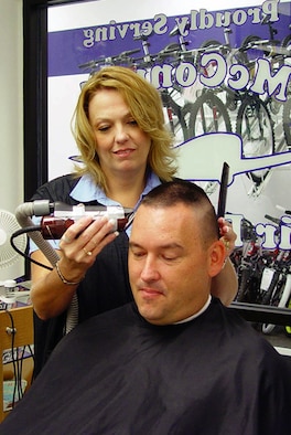MCCONNELL AIR FORCE BASE, Kan. -- Robin Lawley, cuts Charles Smith's hair. Mrs. Lawley is the McConnell Base Exchange barber shop manager, and Mr. Smith is the 22nd Security Forces Squadron information and industrial security manager. Mr. Smith will provide a liver donation to Mrs. Lawley in August. (U.S. Air Force photo by Samantha Housman) 