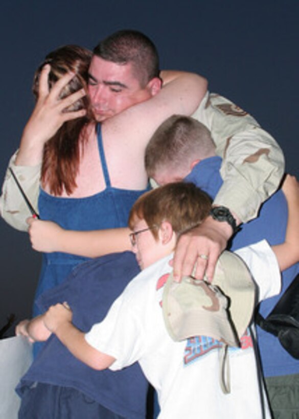 Air Force Tech. Sgt. Rick Bouwhuis is embraced by his family after returning home to Lackland Air Force Base, Texas, on July 10, 2005. Bouwhuis, attached to 37th Security Forces Squadron, returned to Lackland after an eight-month deployment in Iraq. 