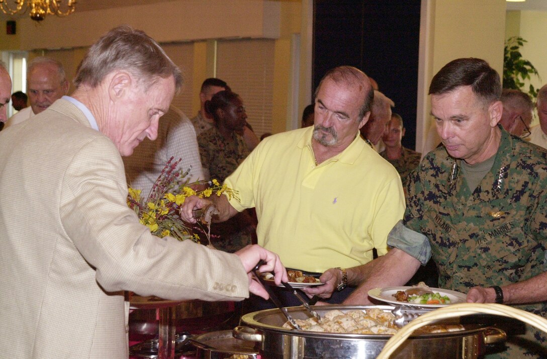 MARINE CORPS BASE CAMP LEJEUNE, N.C. - Les Palm (far left), director of the Marine Corps Association, Quantico, Va., and Assistant Commandant of the Marine Corps Gen. William L. Nyland (right) share kind words as they fill their plates during a luncheon held at the Paradise Point Officer's Club July 28.Nyland attended the luncheon to talk with active duty service members, retired Marines, family members and MCA representatives about the past, present and future of the Marine Corps. (Official Marine Corps photo by Lance Cpl. Matthew K. Hacker)