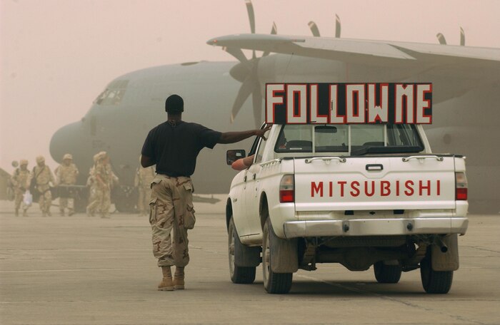 BAGHDAD, Iraq -- Senior Airman Nathan Simmons (left) and Staff Sgt. Johnathan Baker watch British troops board a Royal Air Force C-130 Hercules after it successfully navigated through a dusty sky over central Iraq.  The Airmen are crew chiefs with the 447th Aircraft Maintenance Squadron.  Airman Simmons is deployed from McConnell Air Force Base, Kan.  Sergeant Baker is a reservist from Charleston AFB, S.C.  (U.S. Air Force photo by Master Sgt. Scott Wagers)