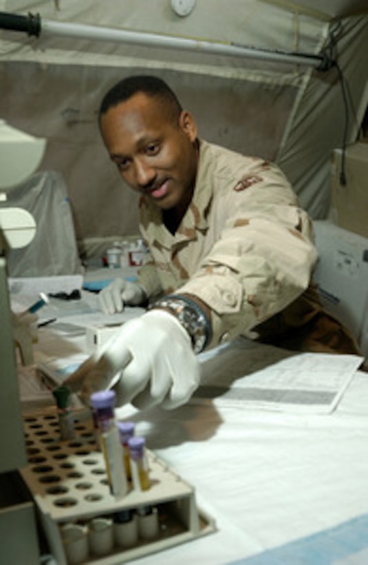 Air Force Medical Lab Technician Sgt. Allen Willridge selects a vial of blood for testing at the Ivory Combat Clinic at Kirkuk Air Base, Iraq, on July 22, 2005. Willridge is attached to the 145th Support Battalion and is one of 70 medical personnel at the clinic, which treats more than 60 people each day. 