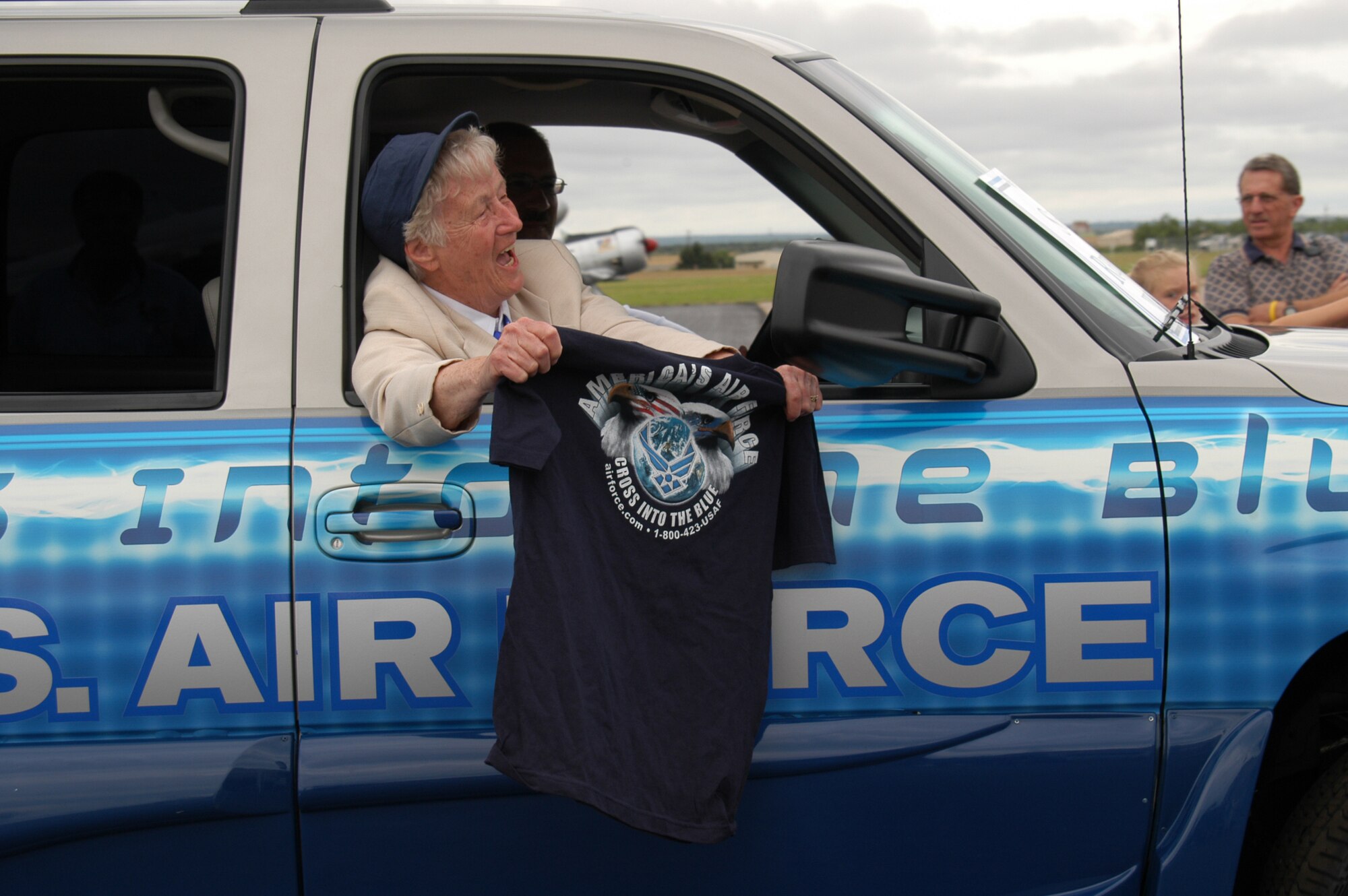 AVENGER FIELD, Texas -- Shutsy Reynolds, one of the Women's Airforce Service Pilots, waves an Air Force T-shirt and cheers as she rides in an Air Force recruiting vehicle during a parade at here.  The parade was held in conjunction with the opening of the National WASP World War II Museum on May 28.  (U.S. Air Force photo by Senior Airman Matthew Rosine)
