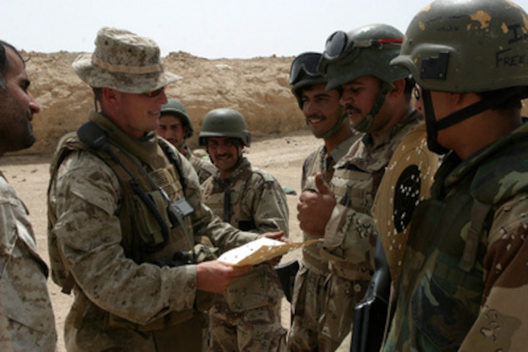 Marine 1st Lt. Charles Godwin (left) evaluates Iraqi Security Force soldiers after weapons training at a firing range in Fallujah, Iraq, on May 13, 2005. Godwin and his fellow Marines of 1st Battalion, 6th Marines are training Iraqi Security Force soldiers to independently maintain control of Iraq. The 2nd Marine Division is conducting security and stabilization operations in the Al Anbar Province of Iraq. 