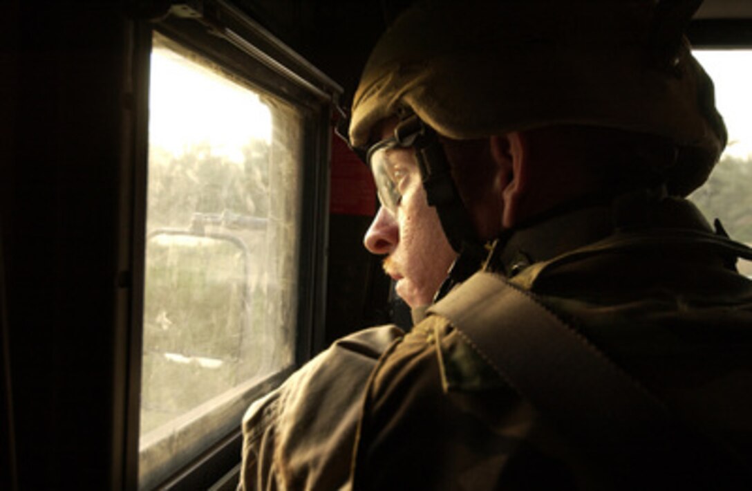 U.S. Army Sgt. 1st Class Joe Flemion examines the defensive positions of the other members of his convoy after hearing small arms fire during an operation in Quryat Al Islatt, Iraq, on May 29, 2005. Flemion and his fellow soldiers of the 2nd Battalion, 34th Armor are part of an Iraqi Army led mission to find contraband and suspected insurgents in and around the village of Quryat Al Islatt. The mission resulted in the arrest of nine suspected insurgents, confiscation of several weapons from AK-47 machine guns to SA-18 surface to air missiles, and illegally obtained Iraqi Army and police uniforms. 