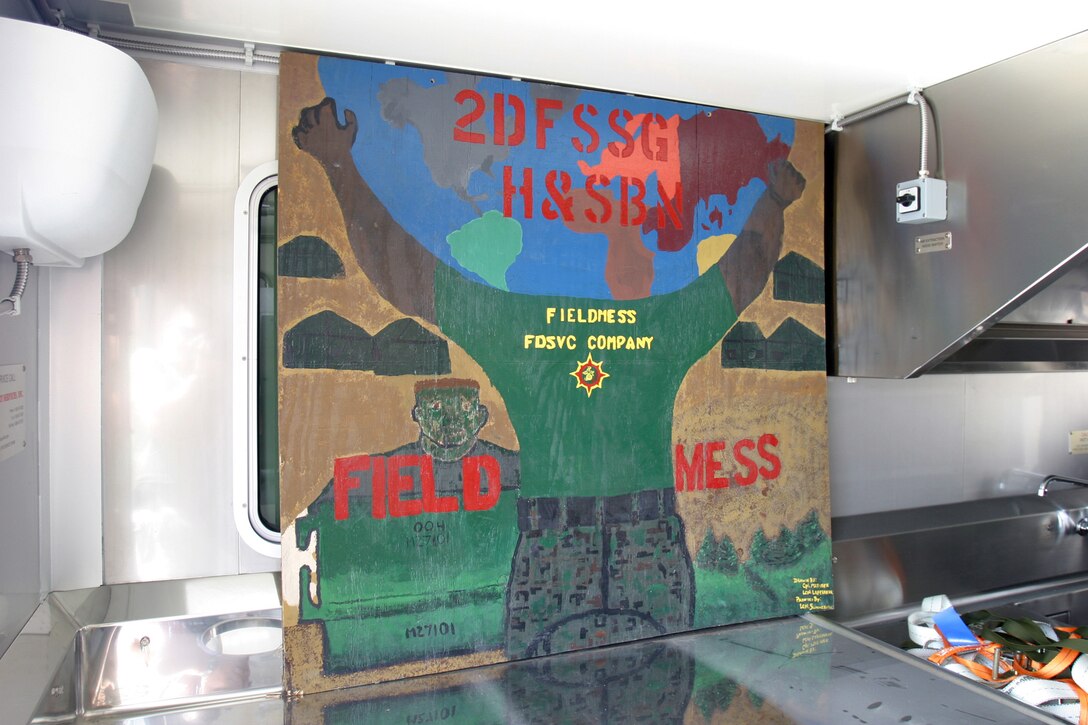 CAMP HIT, Iraq - Food Service Company's Marines painted a sign for their field mess back at Camp Lejeune, N.C.  The sign was loaded and shipped to Iraq to be with a true field mess, according to Sgt. Juan C. AguilarRichard, Camp Hit mess manager and Mission, Texas, native.  (Photo by Cpl. C.J. Yard)