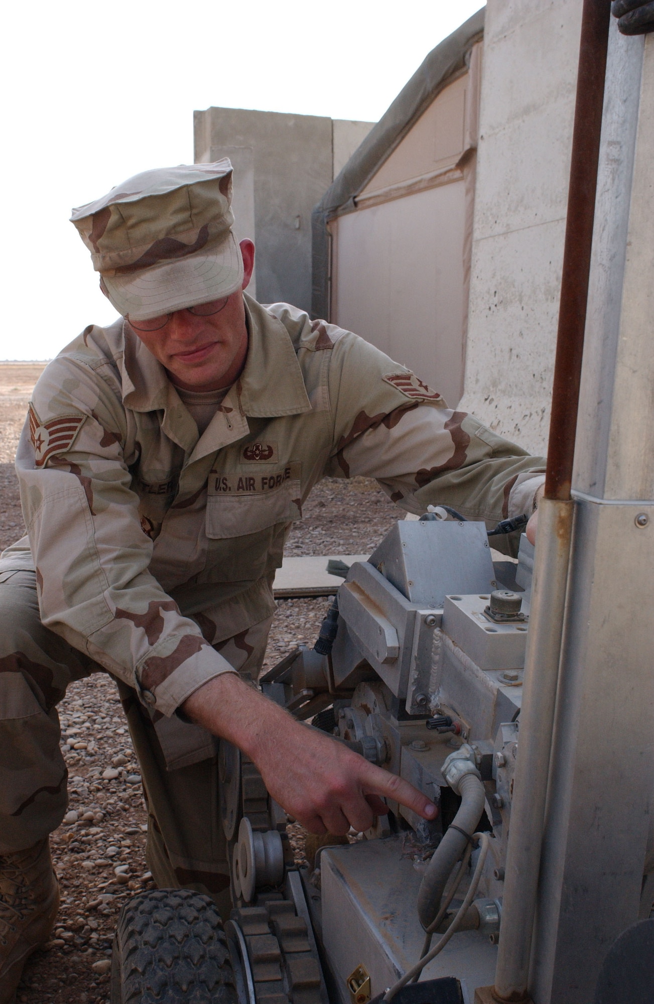 BALAD AIR BASE, Iraq -- Staff Sgt. Robert Butler points out the damage an explosive can cause on an explosive ordnance disposal robot.  He is a 332nd EOD technician here.  (U.S. Air Force photo by Senior Airman Tim Beckham)                 