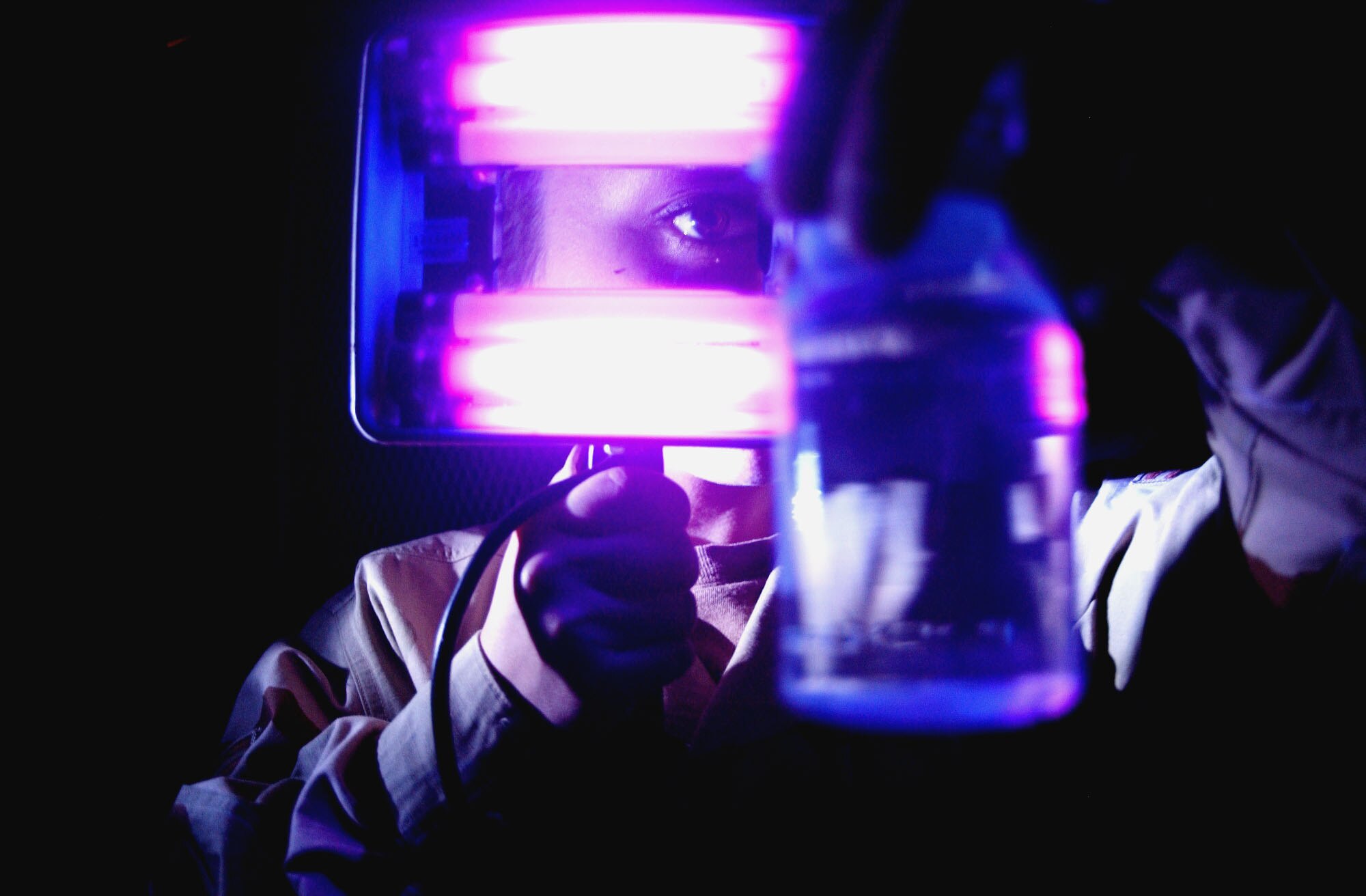 BALAD AIR BASE, Iraq -- Senior Airman Aubrey Pabon checks a water sample for contamination using a blacklight.  She is a bioenvironmental engineering technician with the 332nd Aerospace Medical Squadron.  (U.S. Air Force photo by Senior Airman Tim Beckham)                 