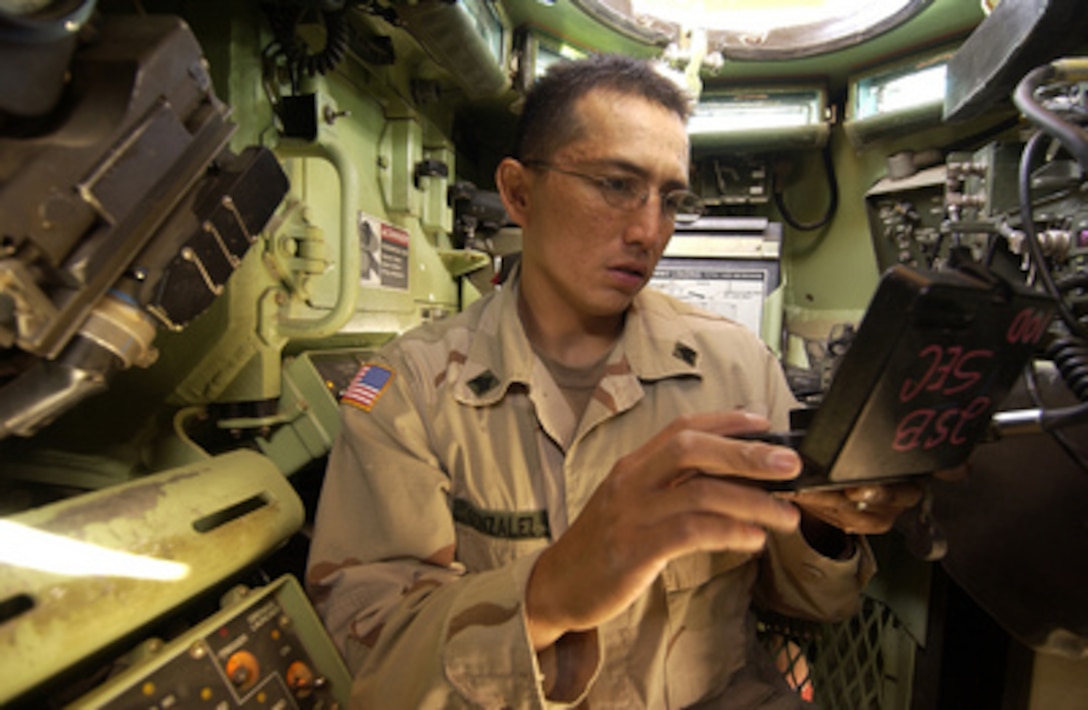 Army Sgt. Christopher Gonzalez programs radio frequencies into the communications systems in an M1A1 Abrams Main Battle Tank prior to a mission in Baqubah, Iraq, on May 27, 2005. Gonzalez is attached to the 3rd Brigade Troop Battalion, 3rd Infantry Division. 