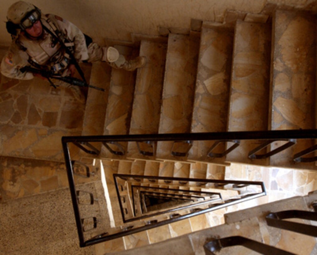 A U.S. Army soldier with Delta Company, 64th Armored Regiment, 4th Brigade, 3rd Infantry Division, stands guard in the rear stairwell during a raid of an office building used by suspected terrorists, in Baghdad, Iraq, on May 30, 2005. The soldiers captured 12 suspects believed to be behind a plot to use chemical weapons against Iraqi Delegates in the International Zone, Baghdad, Iraq. 