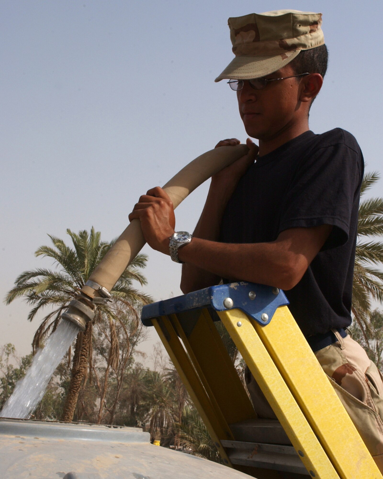 BAGHDAD, Iraq -- Airman 1st Class Juan Rodriguez fills a fresh water tank here.  He is assigned to the 447th Expeditionary Civil Engineer Squadron and is deployed from Kadena Air Base, Japan.  (U.S. Air Force photo by Tech. Sgt. Brian Davidson)                 