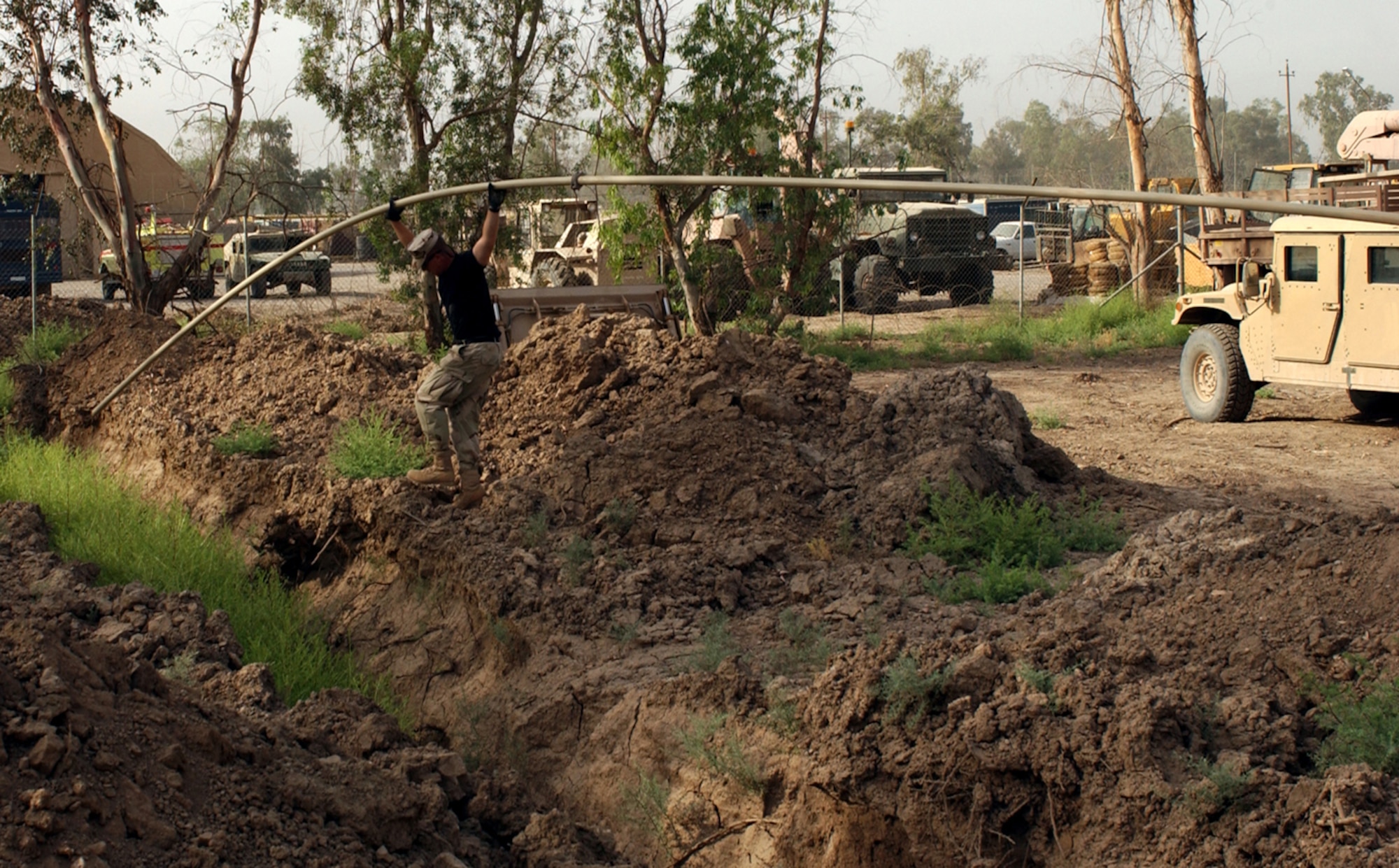 BAGHDAD, Iraq -- Staff Sgt. Sam McCray installs a section of a water pipe.  More than 5,000 feet of pipe has been laid to bring fresh water to people here.  He is assigned to the 447th Expeditionary Civil Engineer Squadron and is deployed from Kadena Air Base, Japan.  (U.S. Air Force photo by Tech. Sgt. Brian Davidson)