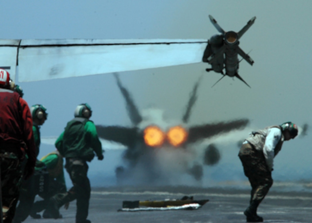 The afterburners of an F/A-18C Hornet bathe the flight deck in heat waves as it launches from the aircraft carrier USS Carl Vinson (CVN 70) on June 1, 2005. The Carl Vinson Carrier Strike Group is conducting operations in support of multi-national forces in Iraq and maritime security operations in the Persian Gulf. Vinson will end its deployment with a homeport shift to Norfolk, Va., to commence a three-year refuel and complex overhaul. 