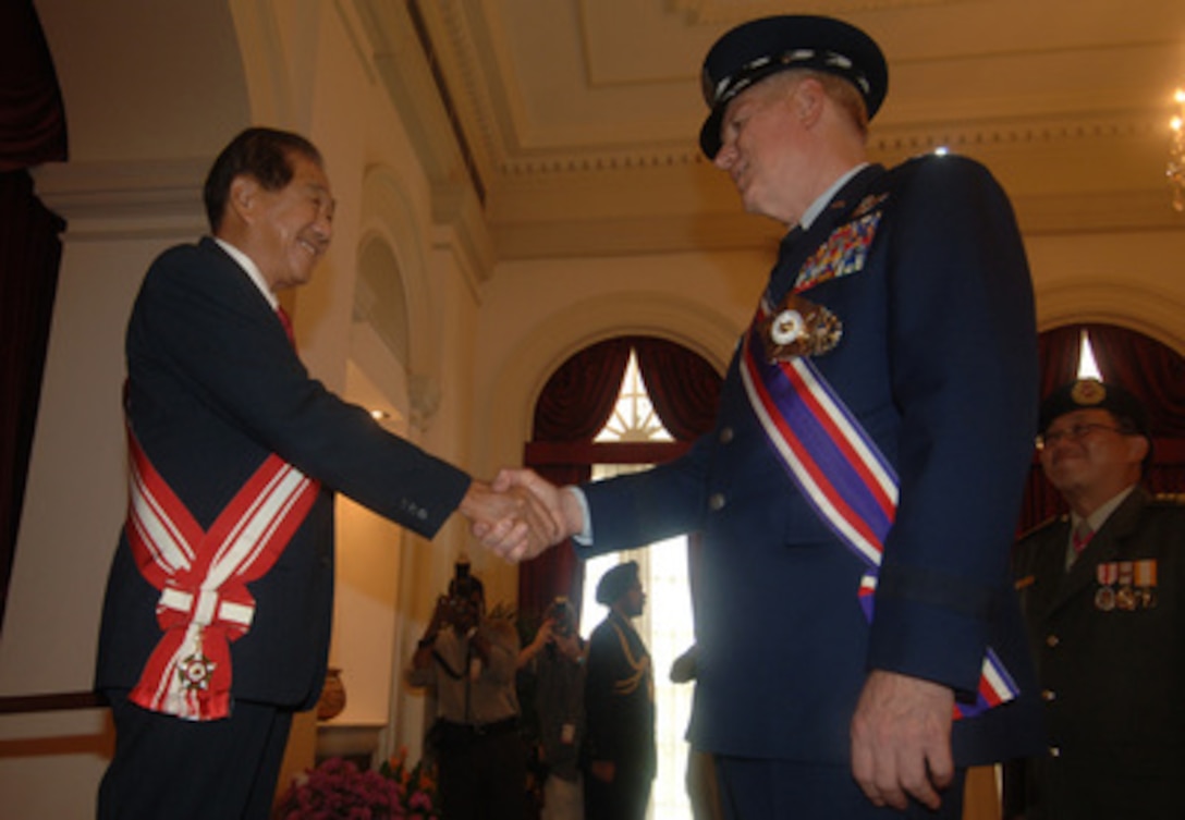 Chairman of the Council of Presidential Advisers and Singapore's Acting President Sim Kee Boon shakes hands with Chairman of the Joint Chiefs of Staff Gen. Richard B. Myers, U.S. Air Force, after awarding him Singapore's Distinguished Service Medal at the Istana in Singapore on June 3, 2005. Myers is in Singapore to attend the 4th International Institute for Strategic Studies Asia Security Conference: The Shangri-La Dialogue with Secretary of Defense Donald H. Rumsfeld. The award is the highest that can be given to a foreigner by the Republic of Singapore. 