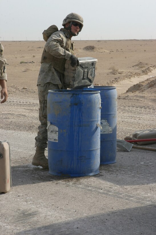 CAMP TAQADDUM, Iraq (June 4, 2005) - Corporal John Clark, a Fowler, Ind., native and heavy equipment operator with Support Company, 8th Engineer Support Battalion, 2d Force Service Support Group (Forward), adds water to concrete mix June 4, while repairing holes on a highly-traveled road. The Marines of 8th ESB conducted Operation San Juan, a five-day operation repairing Alternate Supply Route San Juan, making it safer for convoys and local civilians traveling the road on a daily basis.