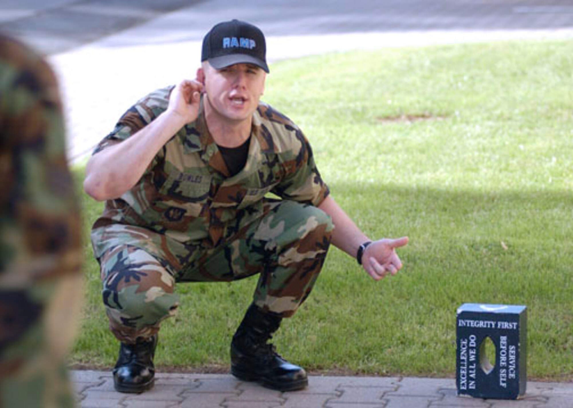 RAMSTEIN AIR BASE, Germany -- Staff Sgt. Mike Bowles explains the blue brick with the Air Force's core values painted on it to candidates inprocessing at Ramstein's Area Motivational Program.  This 30-day program is used by commanders to "reblue" airmen basics through staff sergeants, whose attitude or behavior has deteriorated, resulting in nonjudicial punishment.  The program has been in place here since January 2004 with a high success rate.  Sergeant Bowles is part of the cadre for 120 days and is assigned to the 435th Vehicle Readiness Squadron.  (U.S. Air Force photo by Master Sgt. John E. Lasky)
