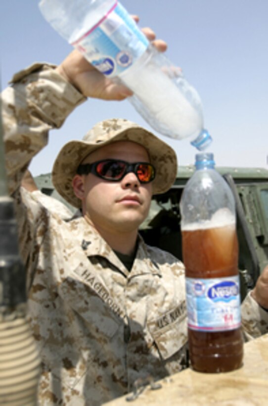 U.S. Navy Corpsman Chad Hagedorn mixes a powdered beverage as he prepares for a convoy from Camp Al Taqaddum, Iraq, on May 31, 2005. U.S. Marines are escorting the convoy to Forward Operating Base Turaybil, Iraq. 