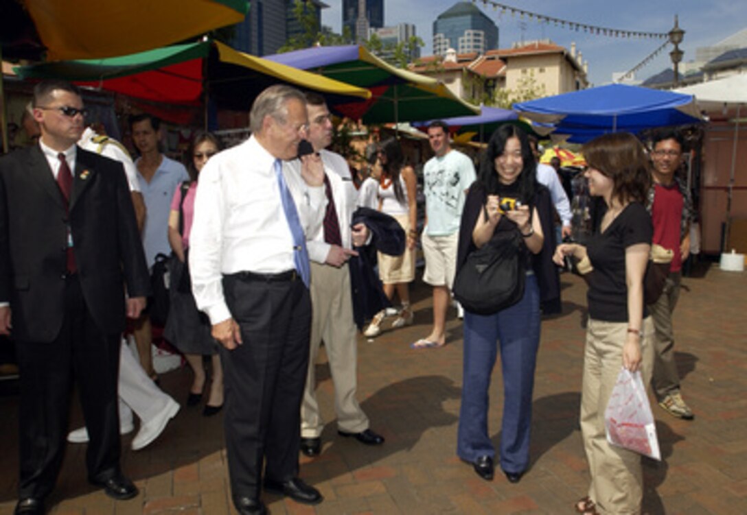 Secretary of Defense Donald H. Rumsfeld talks to two Singapore college students as he walks through Chinatown in Singapore on June 5, 2005. Rumsfeld is in Singapore to attend the 4th International Institute for Strategic Studies Asia Security Conference: The Shangri-La Dialogue in Singapore. The Asia Security Conference brings ministers of defense and other senior officials of Pacific nations together to discuss such topics as terrorism, piracy and defense capabilities in the region. 