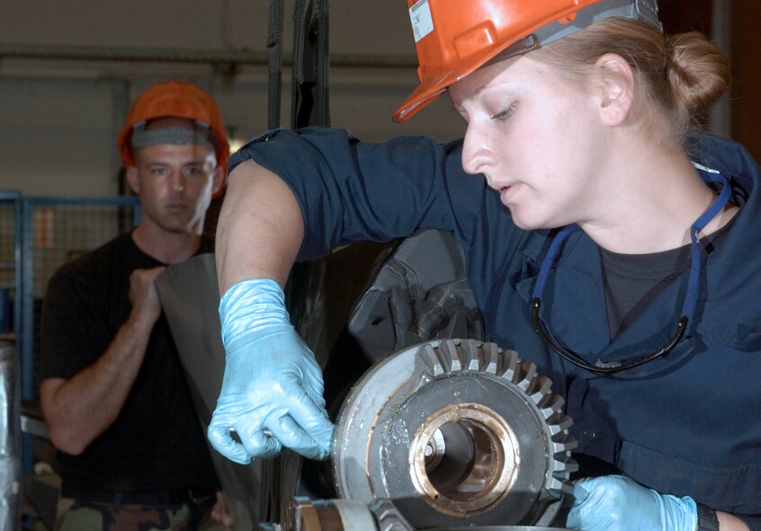 RAMSTEIN AIR BASE, Germany -- Senior Airman Jeffrey Perry (background) holds a C-130 Hercules propeller while Senior Airman Amanda Shetley secures it into position.  The 86th Maintenance Squadron's propulsion flight here is the focal point for any C-130 engines needing repairs in Europe or those deployed supporting operations Iraqi Freedom and Enduring Freedom.  (U.S. Air Force photo by Master Sgt. John E. Lasky)