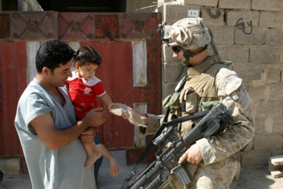 Marine Lance Cpl. Matthew Fordham offers a Iraqi child a package of cookies while conducting search operations in the city of Fallujah, Iraq, on June 1, 2005. Fordham and his fellow Marines of the 6th Marine Regiment, 2nd Marine Division, are working with the Multi-National Force-West in conducting counter-insurgency operations with Iraqi Security Forces. 