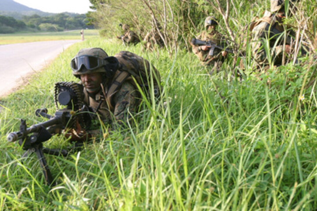 U.S. Marines set up a security position during a simulated raid at the Central Training Area in Okinawa, Japan, on May 26, 2005. The Marines are rehearsing the same tactics and techniques being used in combat operations in Iraq. These Marines are with Company E, 2nd Battalion, 4th Marine Regiment, currently serving as the 31st Marine Expeditionary Unit's battalion landing team. 