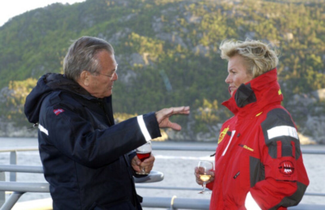 Secretary of Defense Donald H. Rumsfeld talks to Norwegian Minister of Defense Kristin Krohn Devold during a dinner cruise on Lysefjord, in Stavanger, Norway, on June 7, 2005. Rumsfeld is in to meet with Devold and to sign an agreement that will allow the U.S. to preposition weapons and other equipment in Norway. 