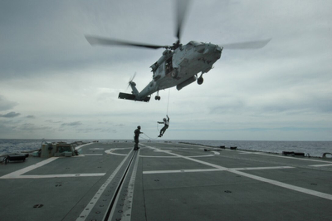 A U.S. Navy HH-60H Seahawk helicopter hovers over the flight deck of HMAS Canberra (FFG 02) while Rear Adm. Jamie D. Kelly, commander of Carrier Strike Group 5, rappels to the deck on June 7, 2005. Kelly is visiting Canberra prior to the aircraft carrier USS Kitty Hawk's (CV 63) participation in Exercise Talisman Saber, a biennial joint forces and combined exercise with the Australian Navy. 