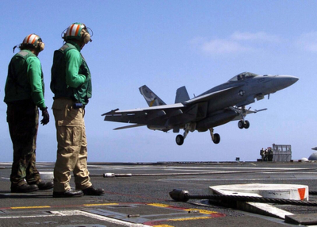 Flight deck crewmen watch as an F/A-18E Hornet performs a touch and go on the flight deck of the USS Abraham Lincoln (CVN 72) on June 6, 2005. The Nimitz-class aircraft carrier and Carrier Air Wing 2 are currently conducting readiness training in the Pacific Ocean. The Hornet is attached to Strike Fighter Squadron 137 of Naval Air Station Lemoore, Calif. 