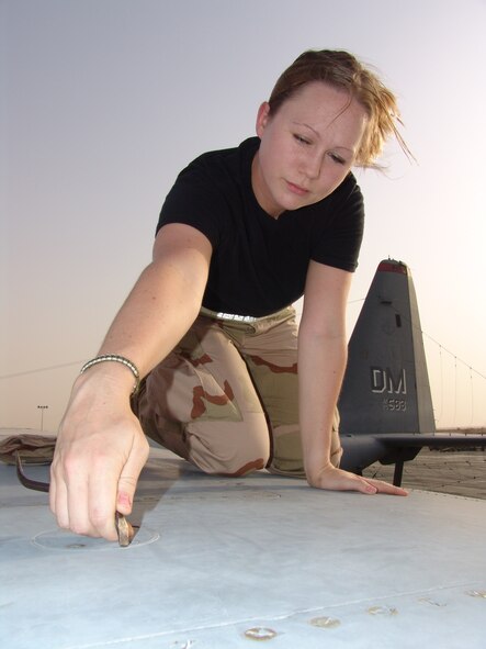 SOUTHWEST ASIA -- Staff Sgt. Emily Frances performs maintenance on an EC-130H Compass Call at a forward-deployed location.  She is an integrated flight controls specialist with the 43rd Expeditionary Electronic Combat Squadron and is deployed from Davis-Monthan Air Force Base, Ariz.  (U.S. Air Force photo by Master Sgt. Al Gerloff)