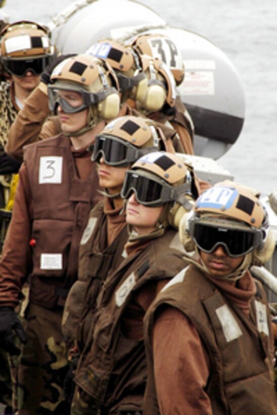 Plane captains assigned to the Strike Fighter Squadron 34 watch flight operations from the catwalk aboard the USS Abraham Lincoln (CVN 72) on June 5, 2005. The Nimitz class aircraft carrier is underway to conduct readiness training at sea. The squadron, known as the Blue Blasters, flies the F/A-18 Hornet and deployed aboard the Lincoln from Naval Air Station Oceana, Va. 
