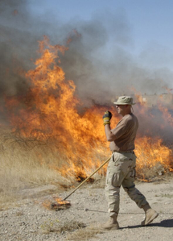 Air Force Master Sgt. James Johnson coordinates a controlled burn at Kirkuk Air Base, Iraq, on June 7, 2005. Johnson and his fellow airmen from the 506th Air Expeditionary Group fire department are conducting the controlled burning of dry grass and weeds to help prevent accidental fires during the hot Iraqi summer. 