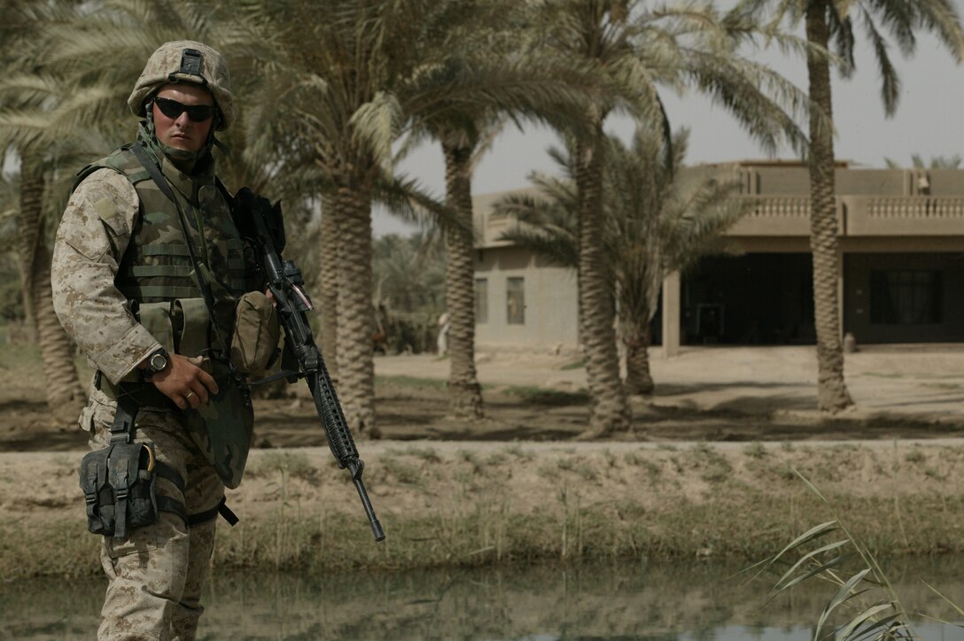 Corporal Robert "Bobby" W. Higdon, 22, Team 2, Detachment 2, 5th Civil Affairs Group, II Marine Expeditionary Force (FWD)and Glen Burnie, Md. native, provides security during a visit to Karmah, Iraq June 9, 2005.