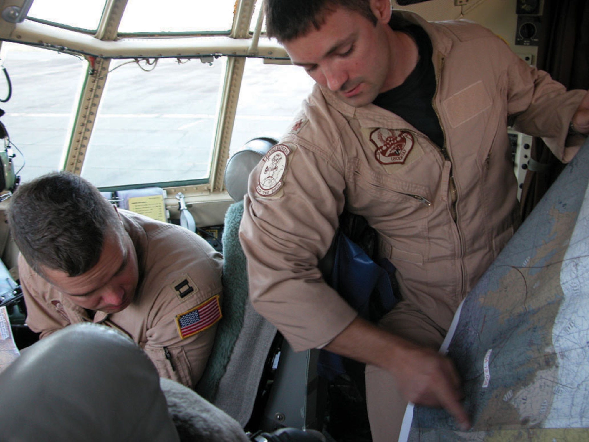 KENYA -- Maj. David. Belfiore reviews chart data with Capt. Brad James before an airdrop June 6.  More than 140 U.S. and Kenyan Army paratroopers left the Kenyan army base landing strip and made successful jumps during the three-day, 14-drop mission.  Both Airmen are assigned to the 746th Air Expeditionary Squadron at a forward-deployed location.  (U.S. Air Force photo by Tech. Sgt. Mark Munsey)