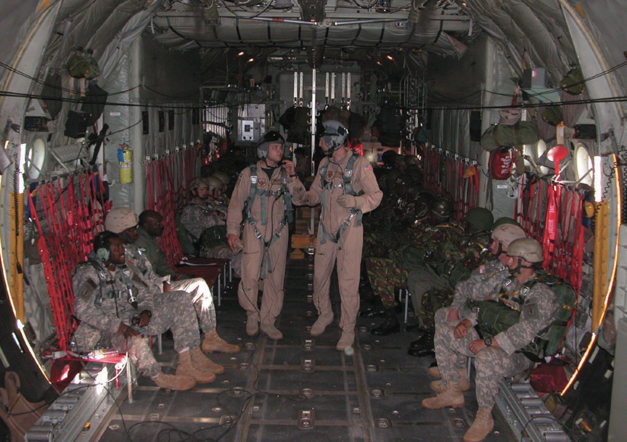 KENYA -- (Standing from left) Senior Airman Jon Kukielka and Tech. Sgt. Eric Wielinga confer on final airdrop procedures before opening cargo doors in the C-130 Hercules on June 6.  The airdrops lasted three days and included 14 separate drops of U.S. and Kenyan Army paratroopers.  The Airmen are loadmasters with the 746th Expeditionary Airlift Squadron at a forward-deployed location.  (U.S. Air Force photo by Tech. Sgt. Mark Munsey)